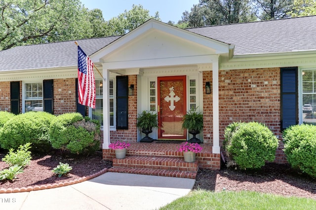 1206 Ivy Ln, Raleigh, NC 27609 - entrance to property featuring brick siding, roof with shingles, and a porch