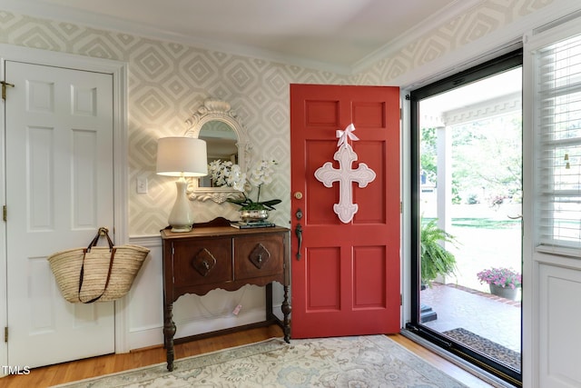 1206 Ivy Ln, Raleigh, NC 27609 - foyer entrance featuring crown molding, wallpapered walls, wood finished floors, and healthy amount of natural light