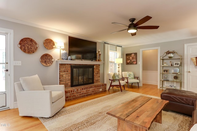 1206 Ivy Ln, Raleigh, NC 27609 - living area featuring wood finished floors, ornamental molding, a brick fireplace, and a ceiling fan