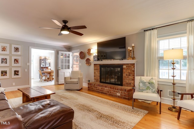 1206 Ivy Ln, Raleigh, NC 27609 - living area featuring wood finished floors, a fireplace, crown molding, a ceiling fan, and baseboards