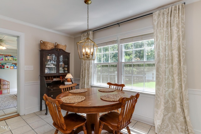 1206 Ivy Ln, Raleigh, NC 27609 - dining room featuring light tile patterned flooring, a chandelier, healthy amount of natural light, a wainscoted wall, and ornamental molding