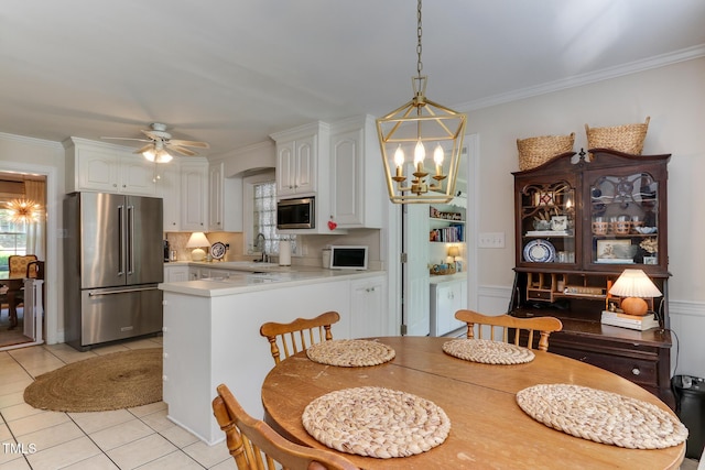1206 Ivy Ln, Raleigh, NC 27609 - dining space with light tile patterned floors, a chandelier, crown molding, healthy amount of natural light, and ceiling fan