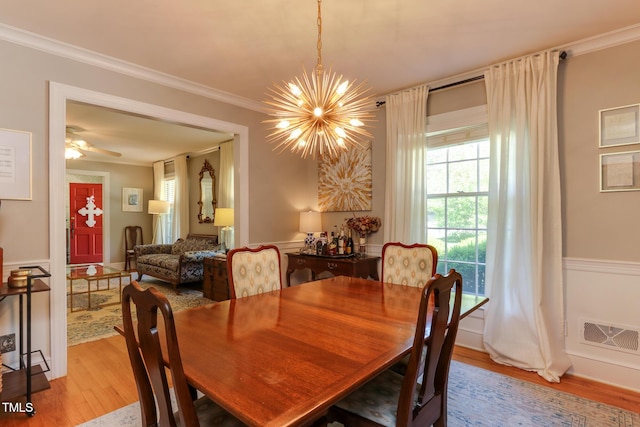 1206 Ivy Ln, Raleigh, NC 27609 - dining space with a chandelier, light wood-style flooring, crown molding, and a wainscoted wall
