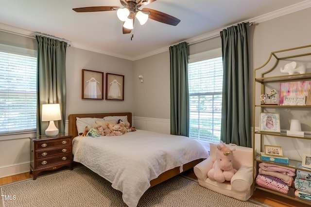 1206 Ivy Ln, Raleigh, NC 27609 - bedroom featuring multiple windows, ornamental molding, wood finished floors, a ceiling fan, and baseboards