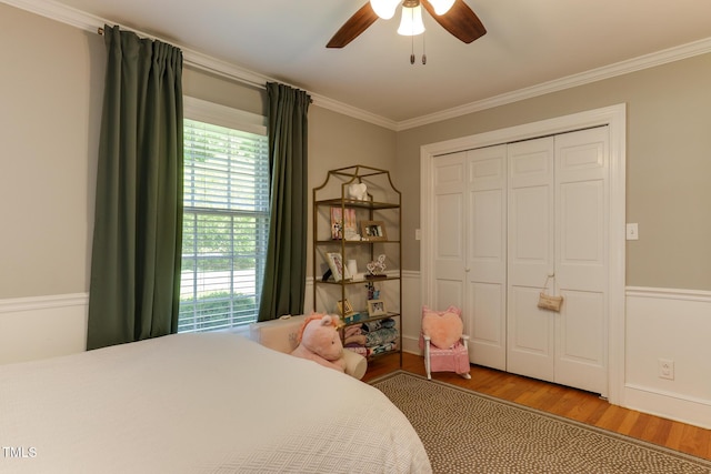 1206 Ivy Ln, Raleigh, NC 27609 - bedroom featuring wood finished floors, multiple windows, ornamental molding, a ceiling fan, and a closet