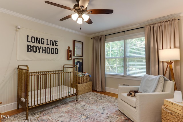 1206 Ivy Ln, Raleigh, NC 27609 - bedroom with crown molding, a nursery area, wood finished floors, baseboards, and ceiling fan