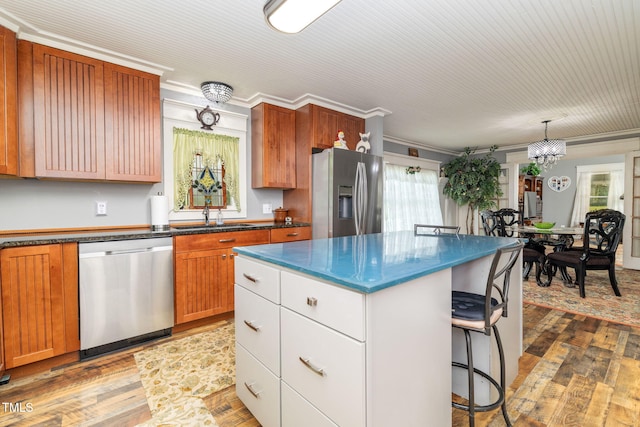 2646 Laurel Mill-Centerville Rd, Louisburg, NC 27549 - kitchen featuring appliances with stainless steel finishes, a sink, a kitchen bar, wood finished floors, and crown molding