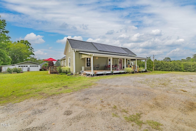 2646 Laurel Mill-Centerville Rd, Louisburg, NC 27549 - view of front of home with covered porch, a front yard, solar panels, an outbuilding, and a detached garage