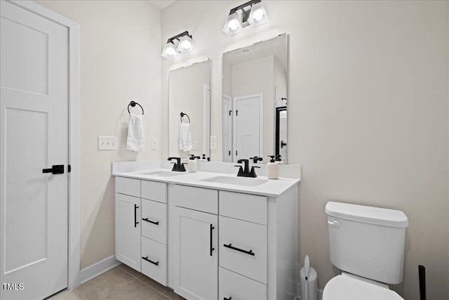 2006 Nola Ln, Durham, NC 27713 - bathroom featuring double vanity, toilet, and baseboards