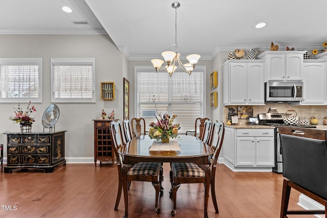 1012 Autumn Meadow Ln, Wake Forest, NC 27587 - dining area with a chandelier, wood finished floors, plenty of natural light, crown molding, and recessed lighting