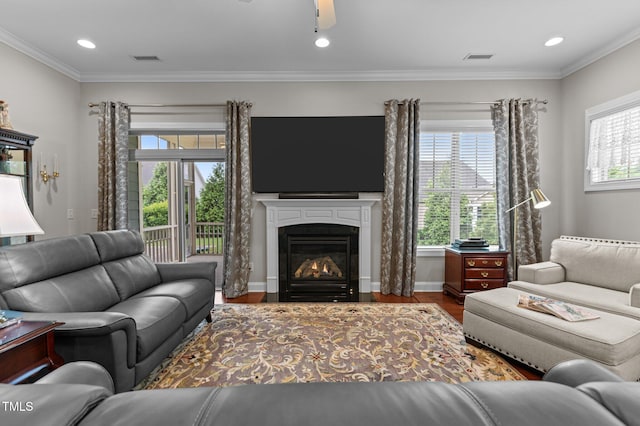 1012 Autumn Meadow Ln, Wake Forest, NC 27587 - living room with wood finished floors, a glass covered fireplace, ceiling fan, crown molding, and recessed lighting