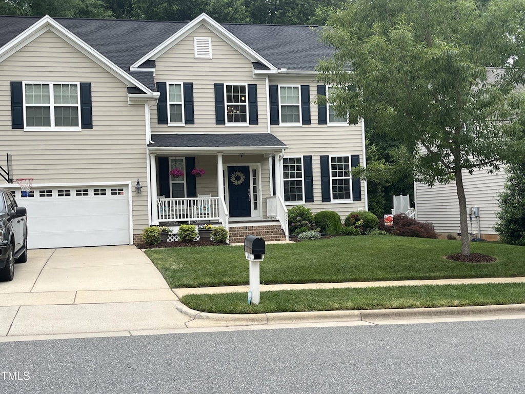 201 Forbes Rd, Wake Forest, NC 27587 - traditional-style house featuring covered porch, a garage, driveway, a front lawn, and roof with shingles