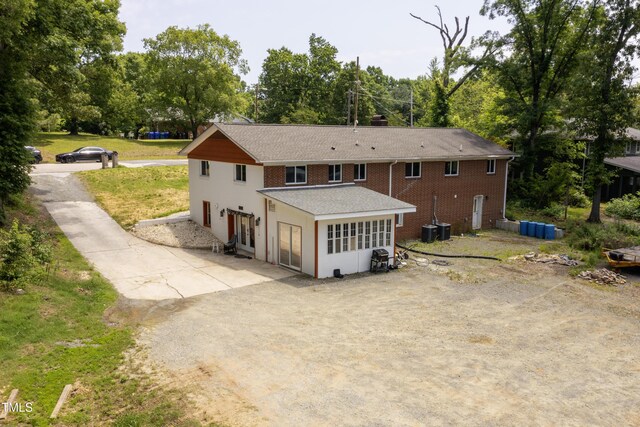 112 S Joyland St, Durham, NC 27703 - back of house featuring a patio area, a shingled roof, brick siding, and view of wooded area