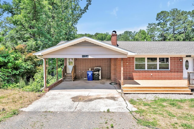 112 S Joyland St, Durham, NC 27703 - view of front of home featuring brick siding, a chimney, a wooden deck, and roof with shingles