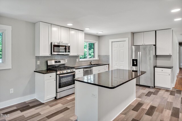 112 S Joyland St, Durham, NC 27703 - kitchen with appliances with stainless steel finishes, a sink, light wood-style floors, backsplash, and recessed lighting