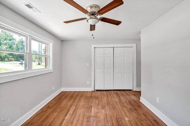 112 S Joyland St, Durham, NC 27703 - unfurnished bedroom featuring baseboards, wood finished floors, a closet, and ceiling fan