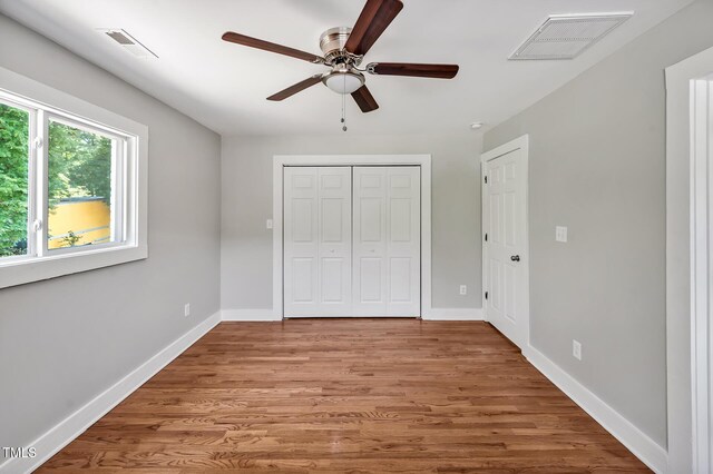 112 S Joyland St, Durham, NC 27703 - unfurnished bedroom with wood finished floors, baseboards, and a closet