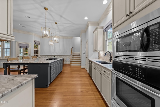 1711 Happiness Hill Ln, Raleigh, NC 27614 - kitchen with stainless steel appliances, a sink, crown molding, a chandelier, and tasteful backsplash