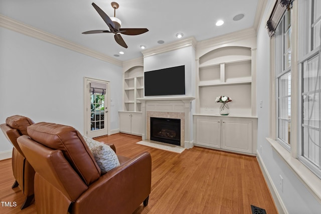 1711 Happiness Hill Ln, Raleigh, NC 27614 - living area with crown molding, a fireplace with flush hearth, baseboards, light wood-style floors, and ceiling fan