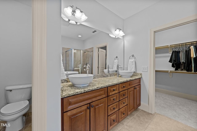 1711 Happiness Hill Ln, Raleigh, NC 27614 - bathroom featuring double vanity, a shower stall, toilet, a spacious closet, and tile patterned floors