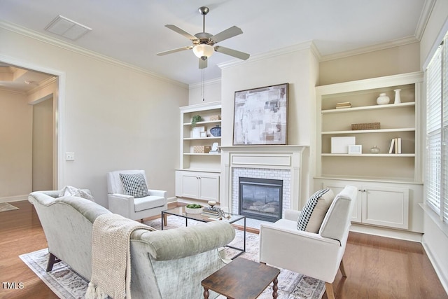 808 Historian St, Raleigh, NC 27603 - living area featuring ceiling fan, wood finished floors, ornamental molding, and a fireplace