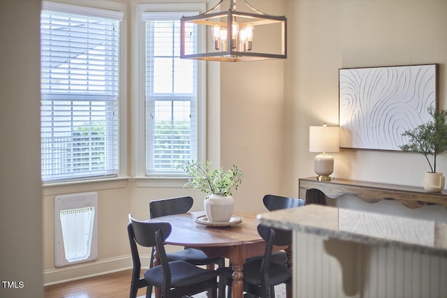 808 Historian St, Raleigh, NC 27603 - dining space with a chandelier, wood finished floors, healthy amount of natural light, and heating unit