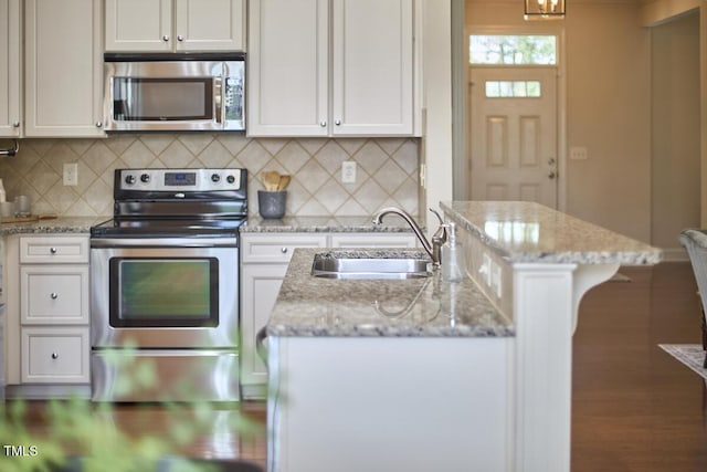 808 Historian St, Raleigh, NC 27603 - kitchen with appliances with stainless steel finishes, backsplash, white cabinetry, and light stone counters