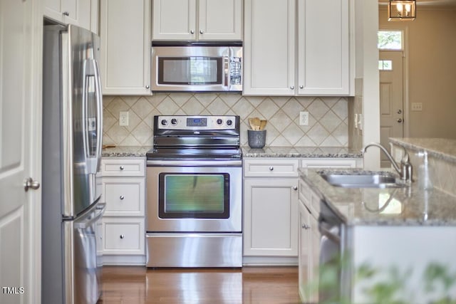 808 Historian St, Raleigh, NC 27603 - kitchen featuring stainless steel appliances, white cabinets, and decorative backsplash