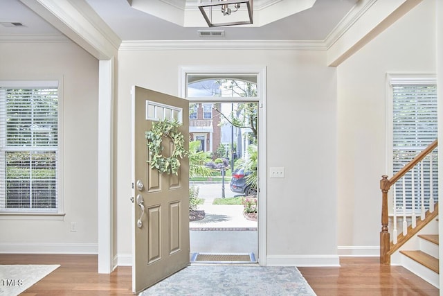 808 Historian St, Raleigh, NC 27603 - entryway featuring wood finished floors, crown molding, stairs, and a chandelier