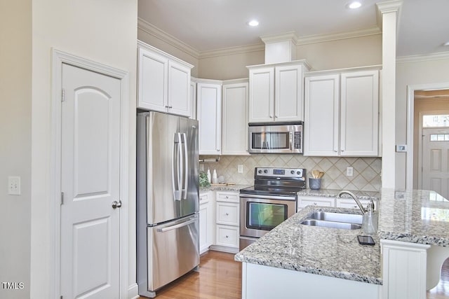 808 Historian St, Raleigh, NC 27603 - kitchen featuring stainless steel appliances, light wood finished floors, white cabinetry, light stone counters, and tasteful backsplash