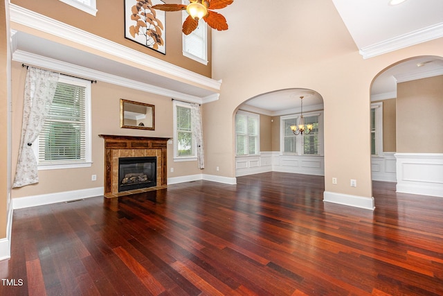 2201 Karns Pl, Raleigh, NC 27614 - unfurnished living room with ceiling fan, wood finished floors, a tile fireplace, arched walkways, and a chandelier