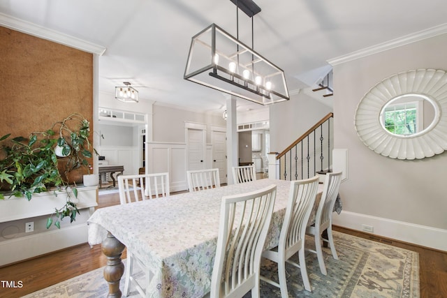 101 Eden Glen Dr, Holly Springs, NC 27540 - dining space with crown molding, wood finished floors, a chandelier, and a decorative wall