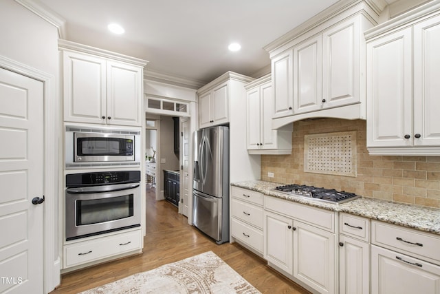 101 Eden Glen Dr, Holly Springs, NC 27540 - kitchen featuring stainless steel appliances, decorative backsplash, white cabinets, light stone countertops, and recessed lighting