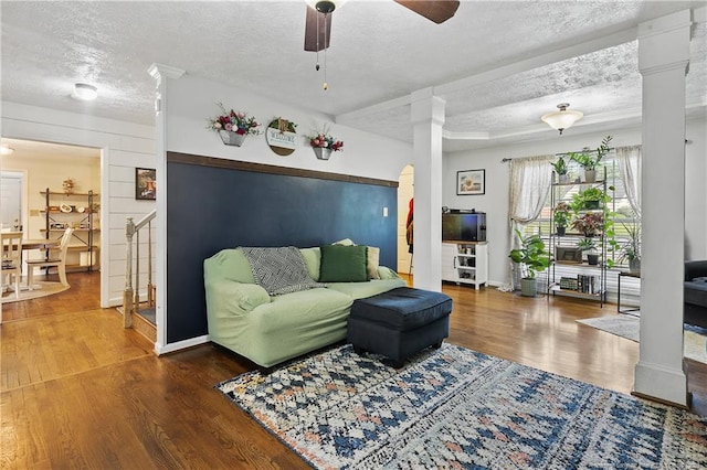 101 Quiet Cv, Raeford, NC 28376 - living room featuring a textured ceiling, decorative columns, wood finished floors, a ceiling fan, and baseboards