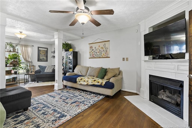 101 Quiet Cv, Raeford, NC 28376 - living room featuring a textured ceiling, ceiling fan, wood finished floors, a tiled fireplace, and baseboards