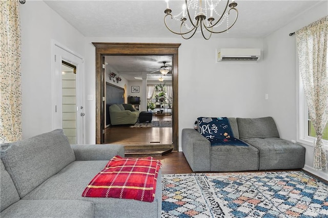101 Quiet Cv, Raeford, NC 28376 - living room featuring a wall unit AC, wood finished floors, a chandelier, and ceiling fan