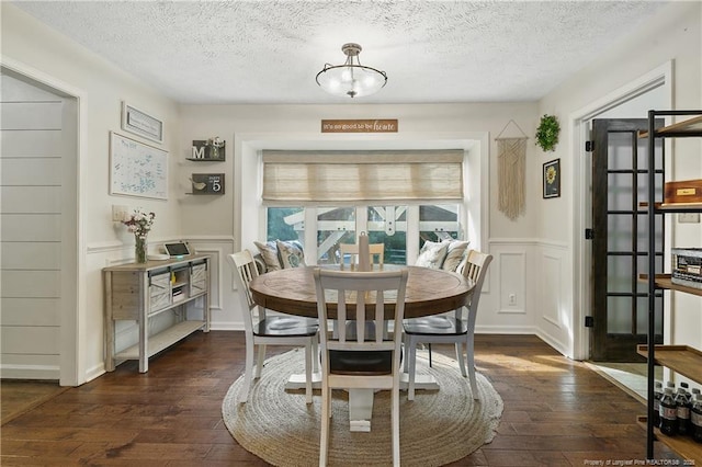 101 Quiet Cv, Raeford, NC 28376 - dining room with dark wood-style floors, a decorative wall, a textured ceiling, and wainscoting
