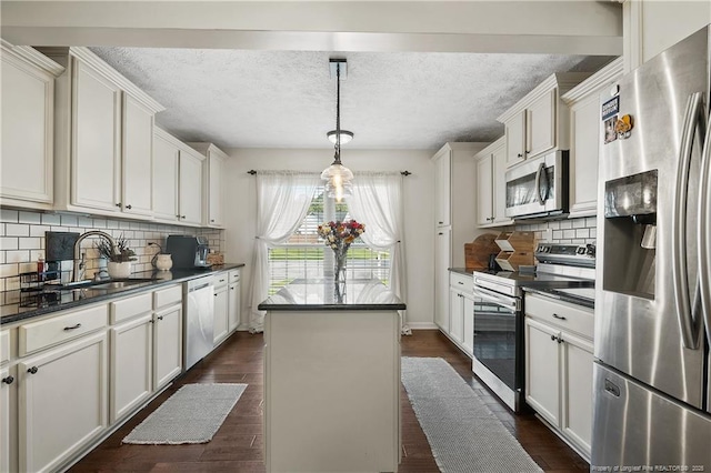 101 Quiet Cv, Raeford, NC 28376 - kitchen with stainless steel appliances, a sink, dark countertops, a center island, and a textured ceiling