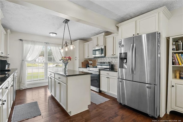 101 Quiet Cv, Raeford, NC 28376 - kitchen featuring appliances with stainless steel finishes, a textured ceiling, dark countertops, a center island, and backsplash
