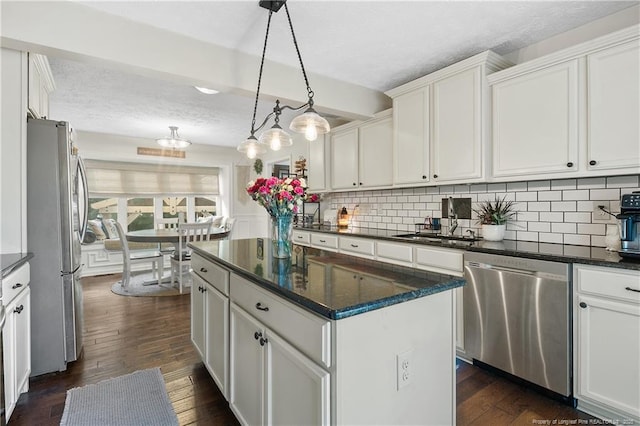 101 Quiet Cv, Raeford, NC 28376 - kitchen featuring stainless steel appliances, a textured ceiling, white cabinetry, backsplash, and a kitchen island