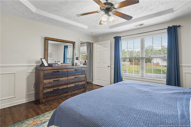 101 Quiet Cv, Raeford, NC 28376 - bedroom featuring a textured ceiling, dark wood-style flooring, a tray ceiling, ornamental molding, and a decorative wall