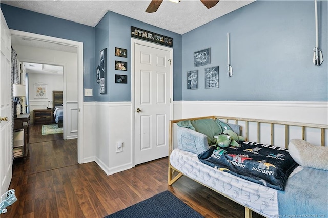 101 Quiet Cv, Raeford, NC 28376 - bedroom featuring a wainscoted wall, dark wood finished floors, a ceiling fan, and a textured ceiling