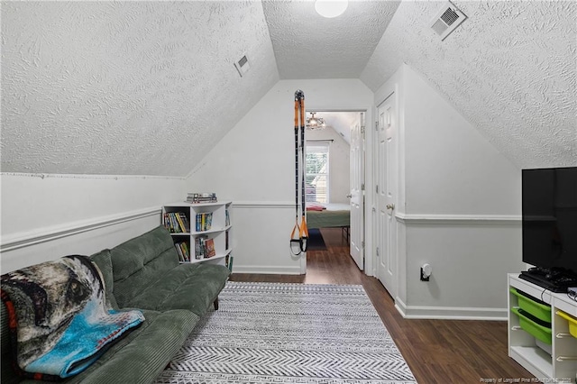 101 Quiet Cv, Raeford, NC 28376 - living area featuring a textured ceiling, wood finished floors, vaulted ceiling, and baseboards