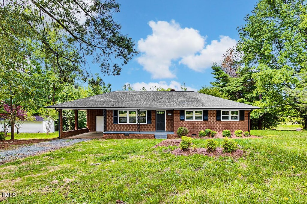 1592 Boone Rd, Elon, NC 27244 - single story home with gravel driveway, a front lawn, an attached carport, and brick siding