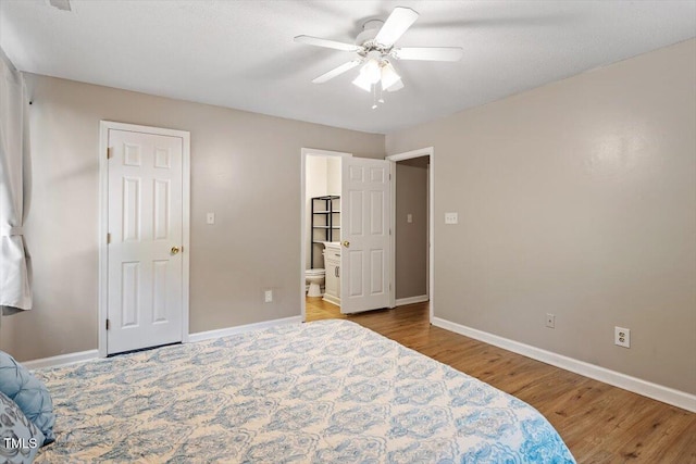 2010 Quaker Lndg Unit 102, Raleigh, NC 27603 - bedroom with baseboards, wood finished floors, ensuite bathroom, and ceiling fan