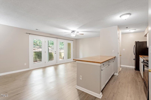 2010 Quaker Lndg Unit 102, Raleigh, NC 27603 - kitchen with ceiling fan, light wood finished floors, a textured ceiling, and baseboards