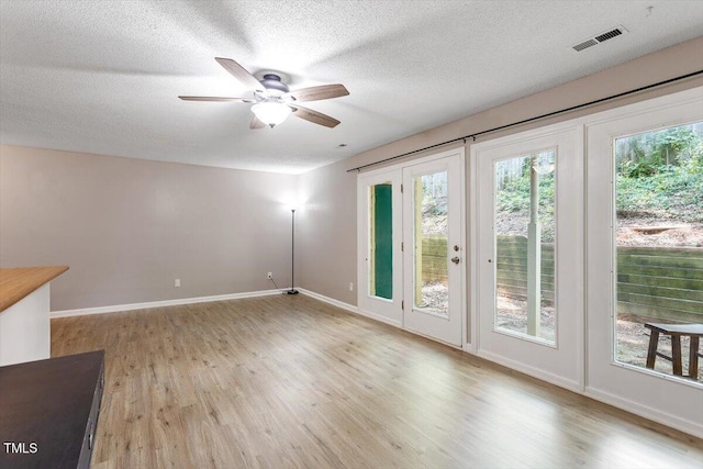 2010 Quaker Lndg Unit 102, Raleigh, NC 27603 - spare room featuring light wood-style flooring, a ceiling fan, a textured ceiling, and baseboards