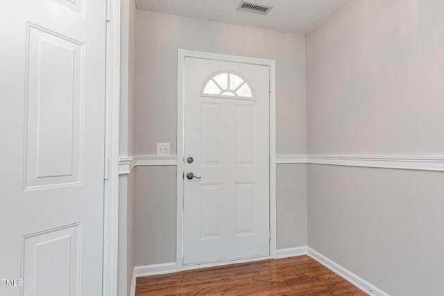 503 Kinship Ln, Apex, NC 27502 - doorway featuring wood finished floors, baseboards, and a textured ceiling