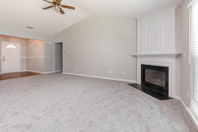 503 Kinship Ln, Apex, NC 27502 - unfurnished living room featuring carpet flooring, a large fireplace, ceiling fan, vaulted ceiling, and baseboards