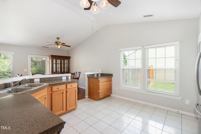 503 Kinship Ln, Apex, NC 27502 - kitchen with a ceiling fan, a sink, lofted ceiling, dark countertops, and light tile patterned floors
